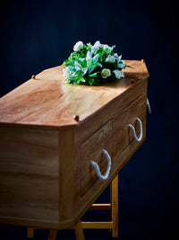 Premium Forest Board Coffin with white floral arrangement